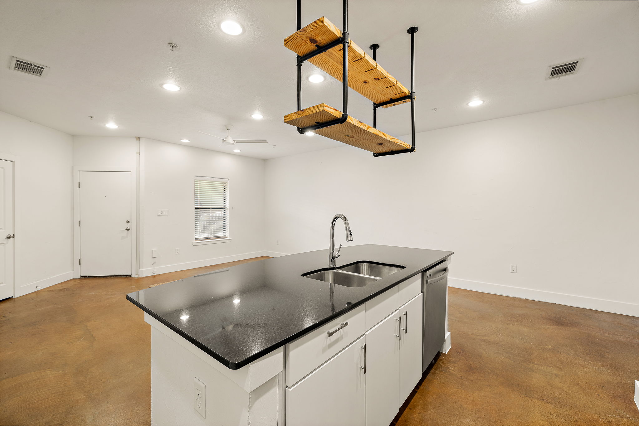 1807 Poquito Street, Unit 41 Austin, TX 78702 - Photo 14 of 23 Kitchen with concrete floors, a center island with sink, white cabinets, recessed lighting, and decorative light fixtures