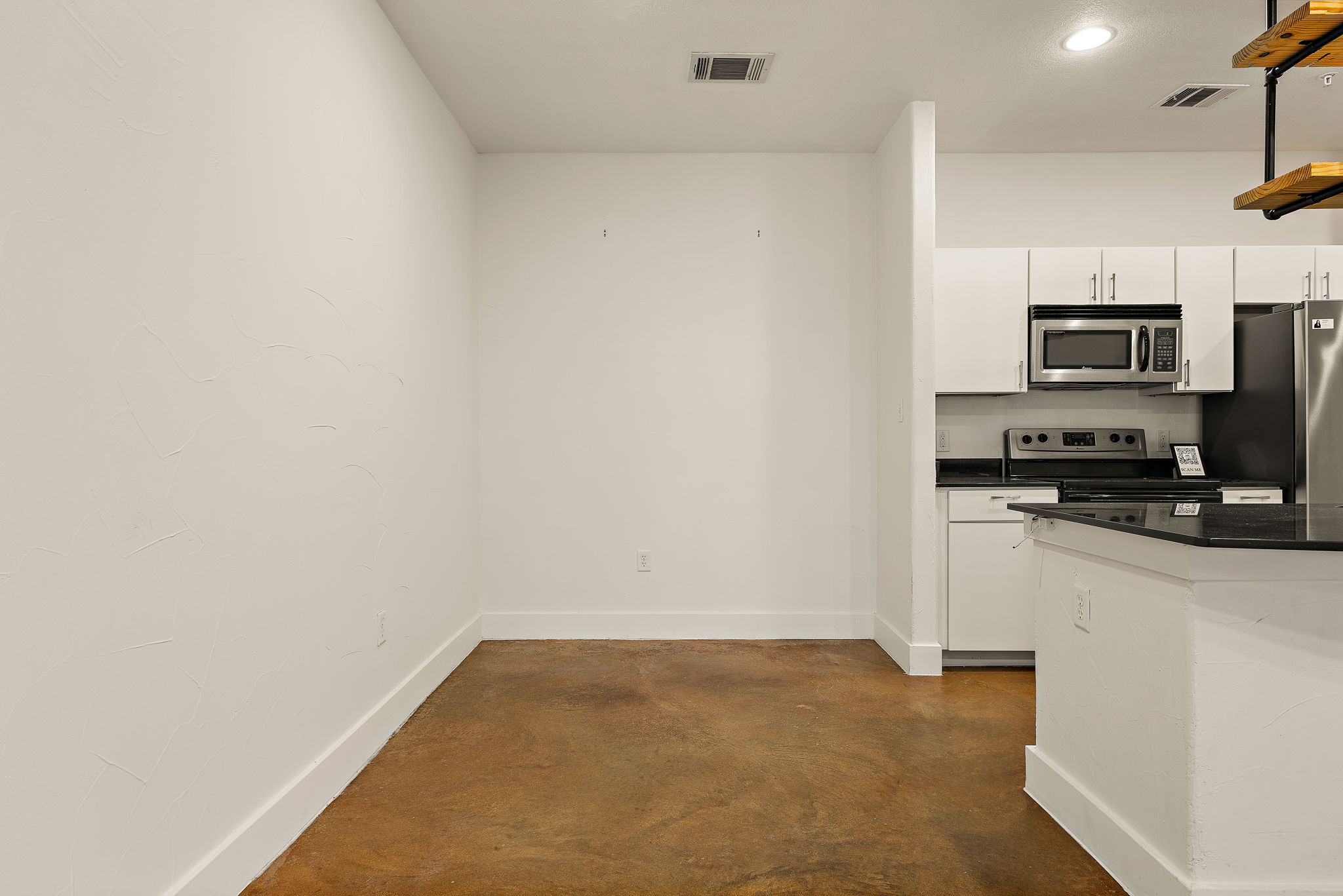 1807 Poquito Street, Unit 41 Austin, TX 78702 - Photo 16 of 23 Kitchen featuring appliances with stainless steel finishes, white cabinets, concrete flooring, dark stone countertops, and recessed lighting