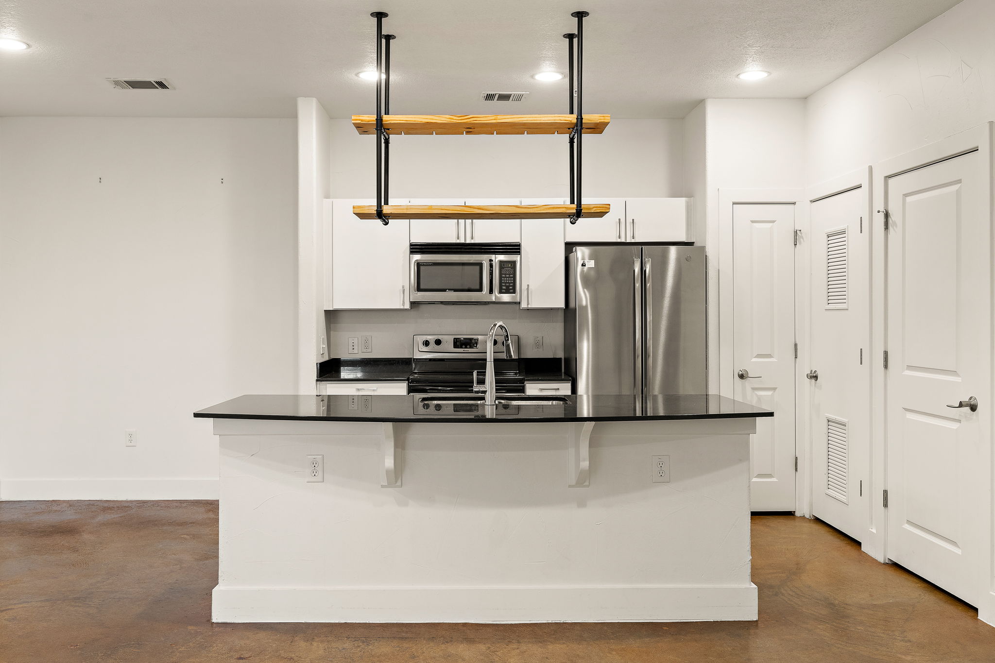 1807 Poquito Street, Unit 41 Austin, TX 78702 - Photo 9 of 23 Kitchen featuring stainless steel appliances, white cabinets, an island with sink, finished concrete flooring, and recessed lighting