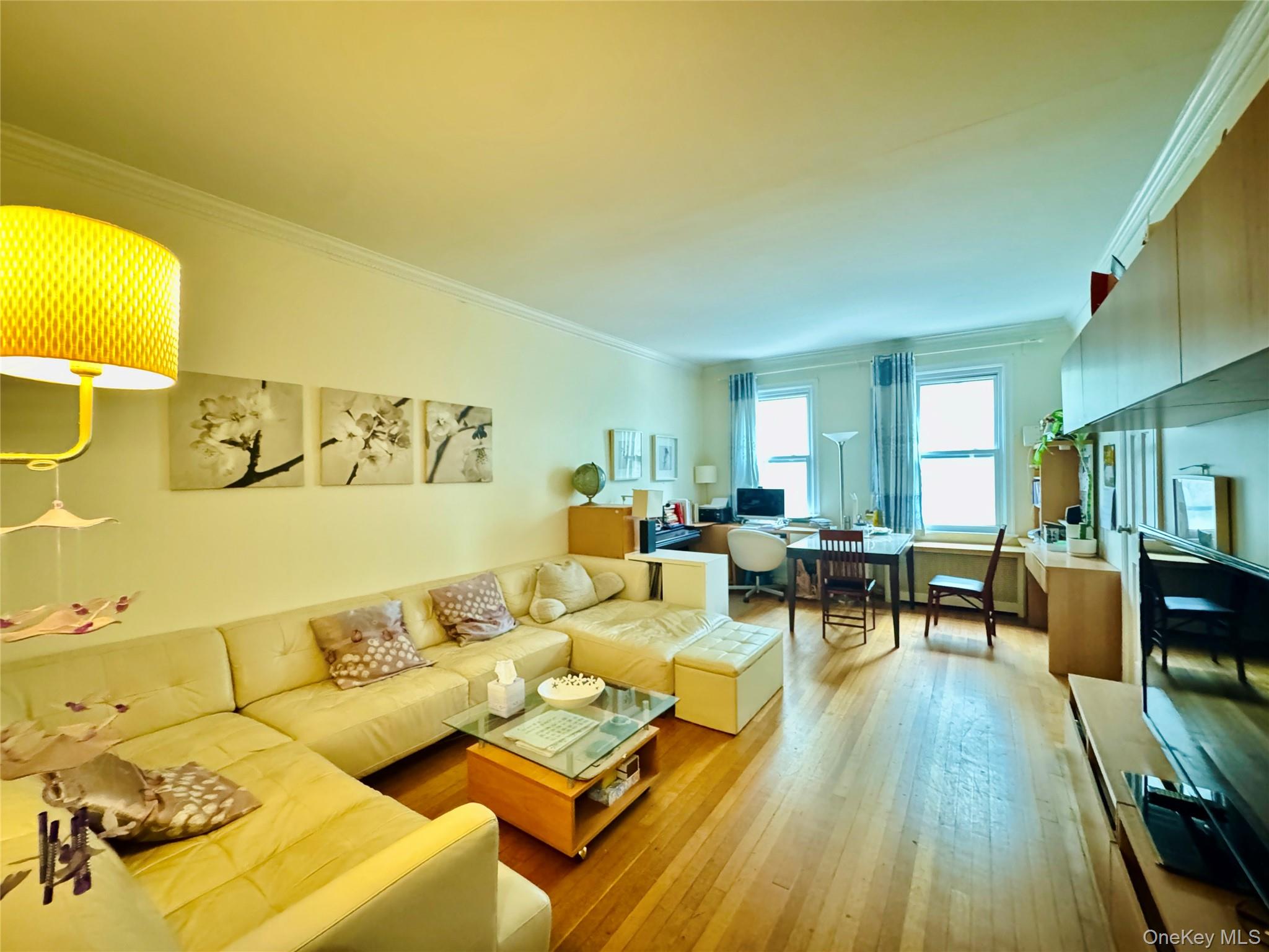 117-14 Union Turnpike, Unit AC3 Queens, NY 11415 - Photo 3 of 14 a living room with couches and kitchen view with wooden floor