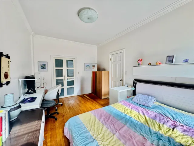 a bedroom with bed and wooden floor