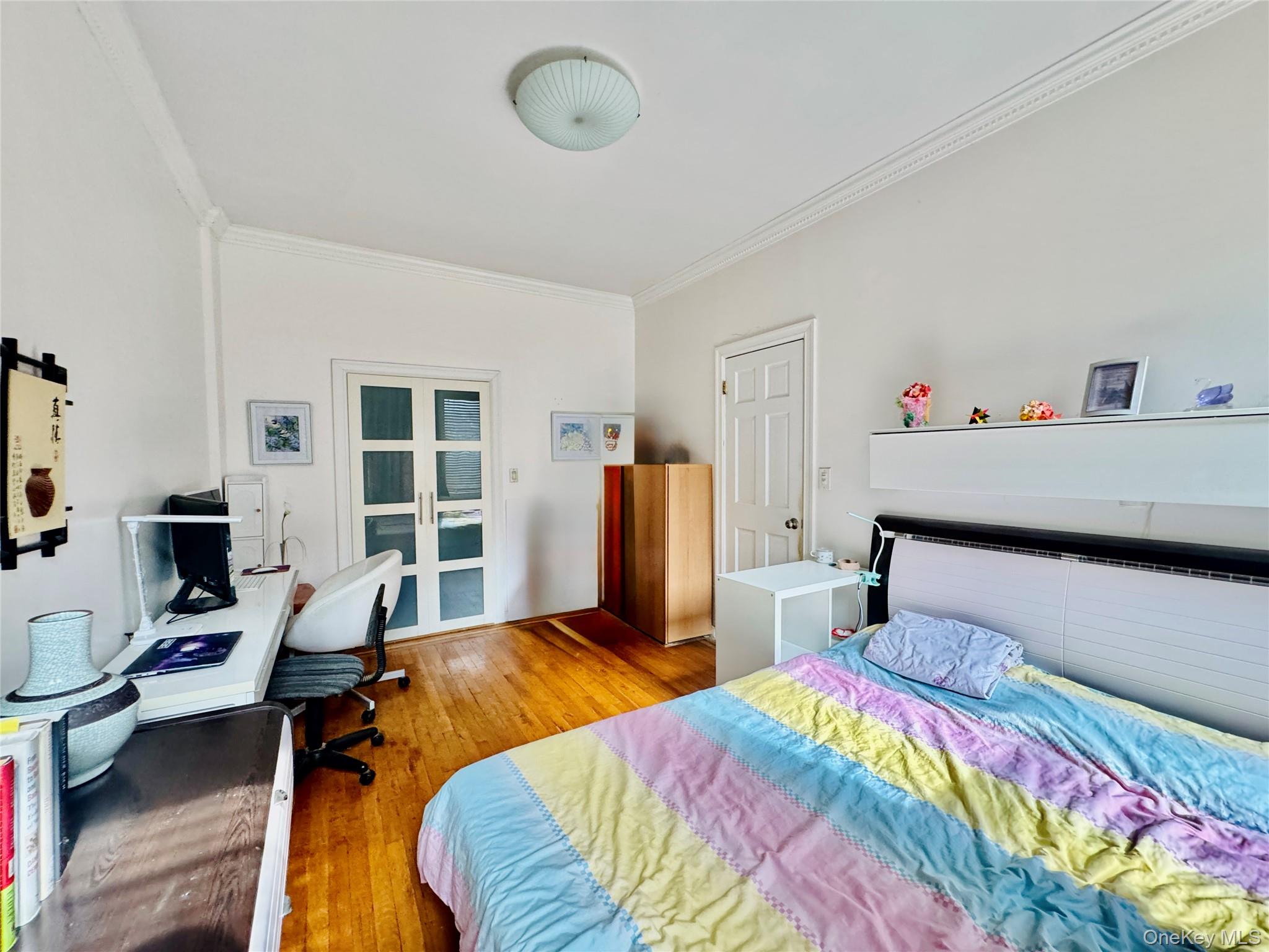 117-14 Union Turnpike, Unit AC3 Queens, NY 11415 - Photo 9 of 14 a bedroom with bed and wooden floor