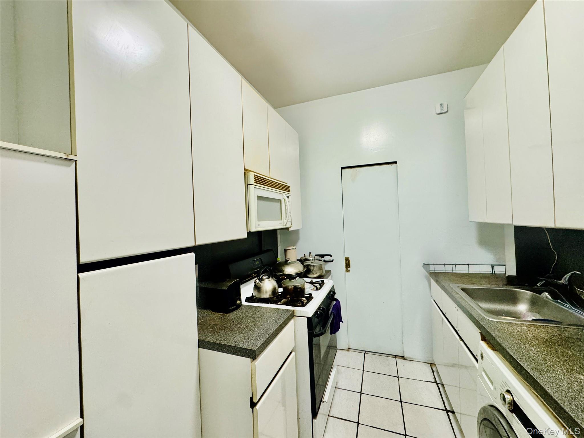 117-14 Union Turnpike, Unit AC3 Queens, NY 11415 - Photo 10 of 14 a kitchen with a sink and a refrigerator