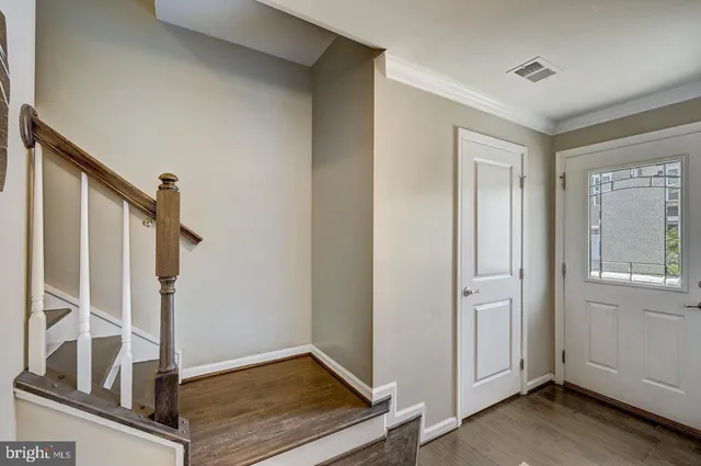 a view of an entryway with wooden floor and staircase