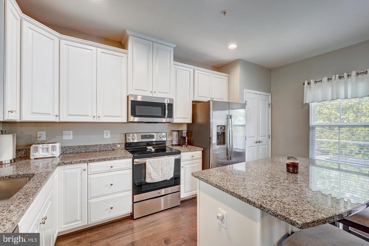8102 Secluded Cove Lane Baltimore, MD 21222 - Photo 7 of 23 a kitchen with granite countertop a sink stainless steel appliances and white cabinets