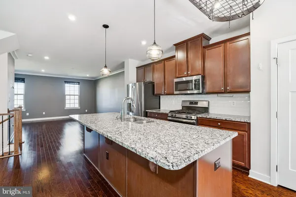 a kitchen with stainless steel appliances granite countertop a sink stove and microwave