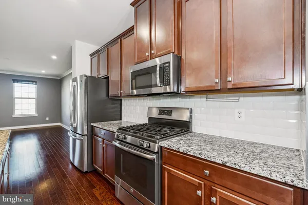 a kitchen with granite countertop stainless steel appliances and wooden cabinets