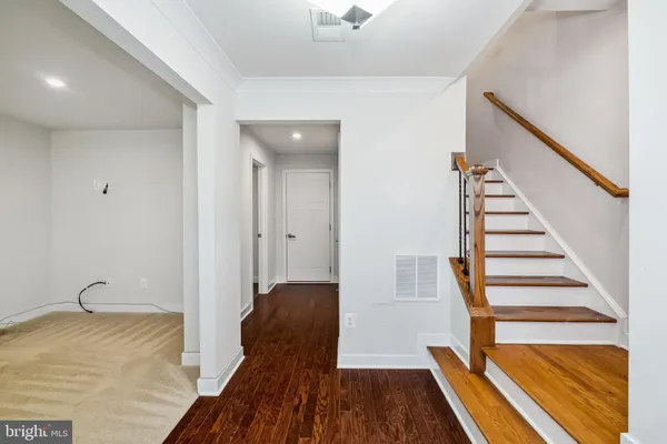 a view of a hallway with wooden floor and staircase