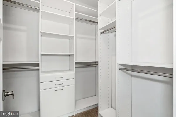 a view of walk in closet with empty racks