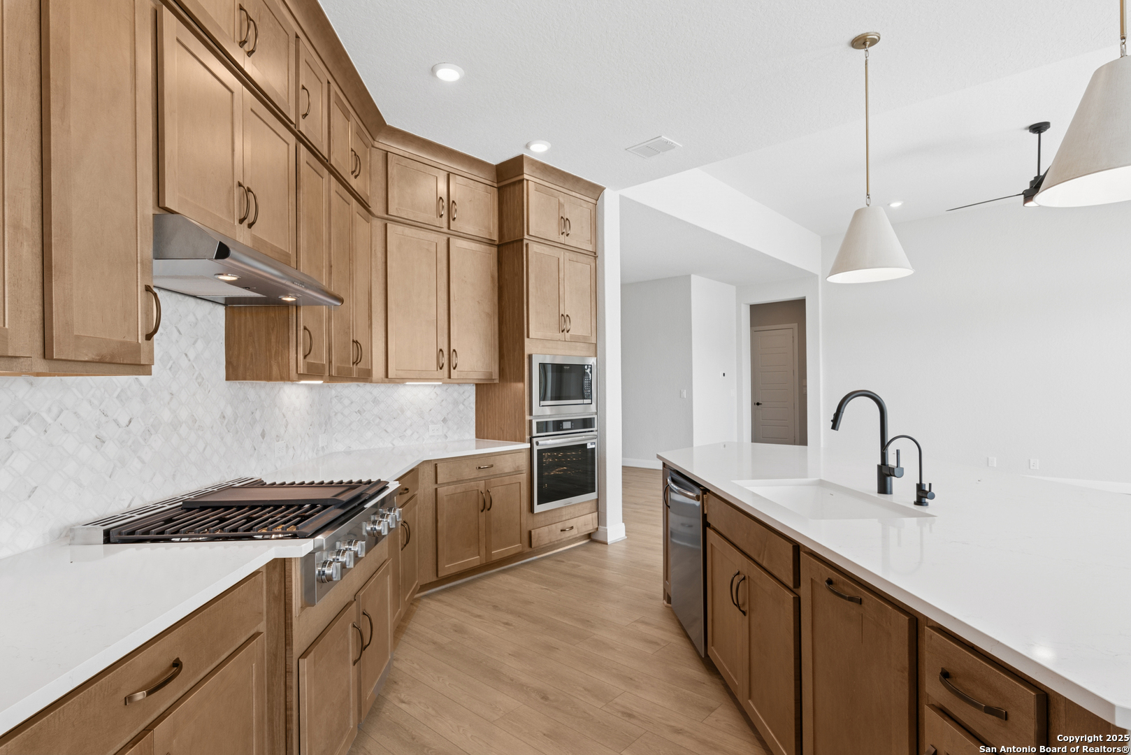212 Brandon Cove Castroville, TX 78009 - Photo 23 of 36 a kitchen with stainless steel appliances granite countertop a sink a stove and a refrigerator