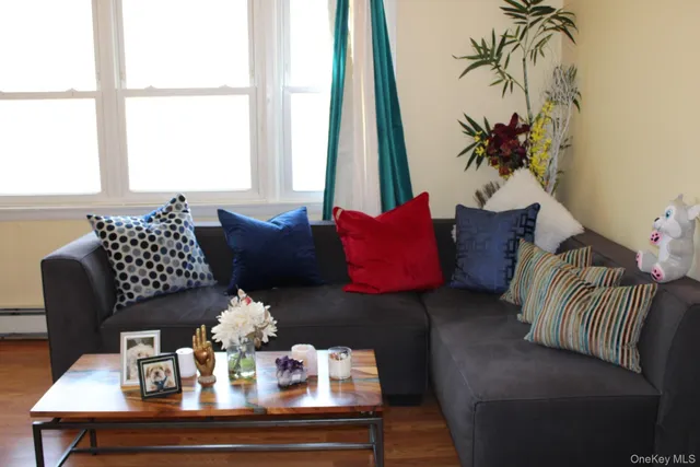 a living room with furniture a flat screen tv and a window