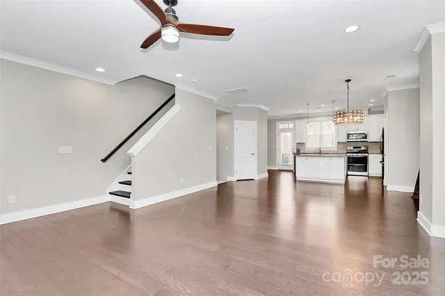 a view of kitchen with stainless steel appliances kitchen island granite countertop a refrigerator a couch and a stove top oven