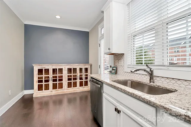 a kitchen with granite countertop a sink stainless steel appliances and window