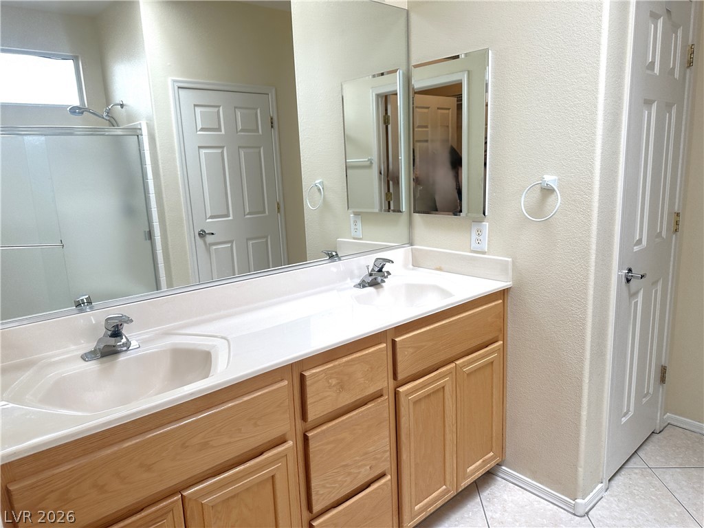 3034 Canal Walk Road Henderson, NV 89052 - Photo 13 of 24 This bathroom offers dual vanities with a large mirror and a spacious shower.