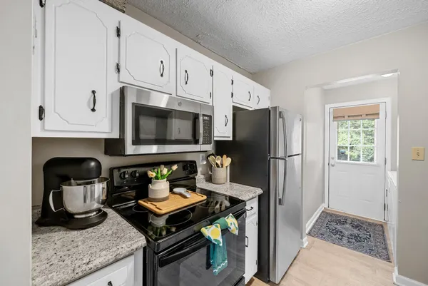 a kitchen with a stove a refrigerator and cabinets