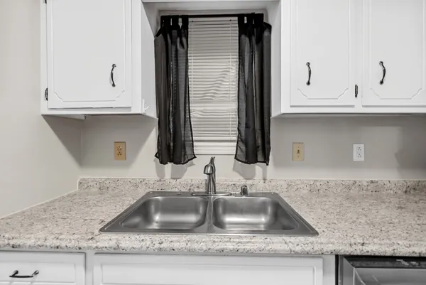 a kitchen with granite countertop a sink and cabinets
