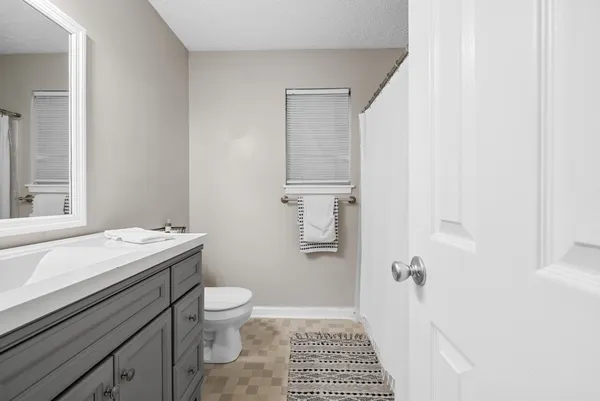 a bathroom with a sink a toilet a shower and a mirror