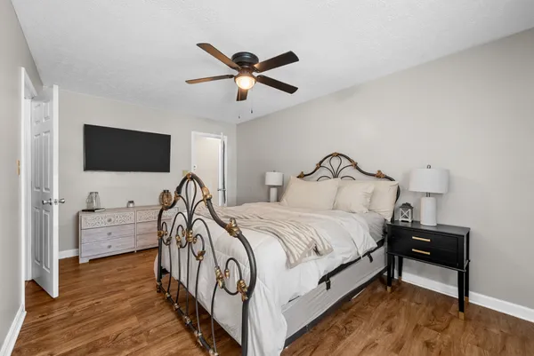 a bedroom with bed and a flat tv screen on dresser