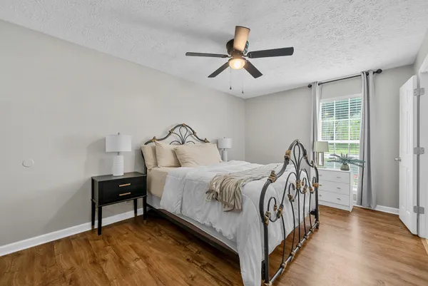 a bedroom with a bed and wooden floor