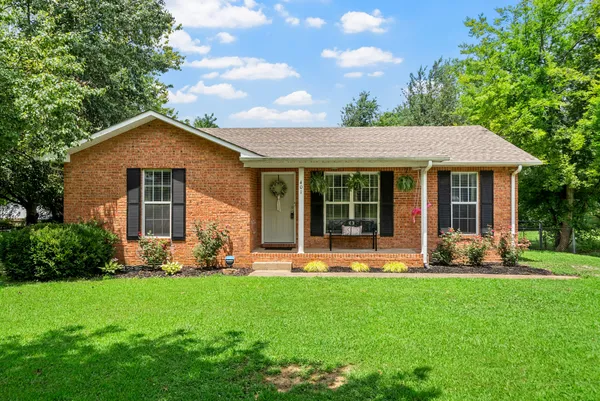 a front view of a house with a yard and green space