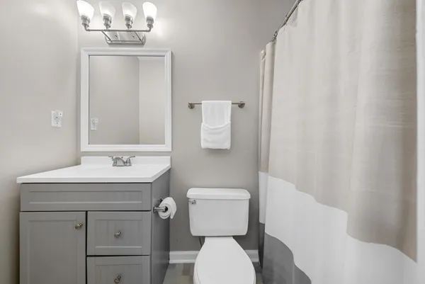 a bathroom with a toilet a sink and mirror