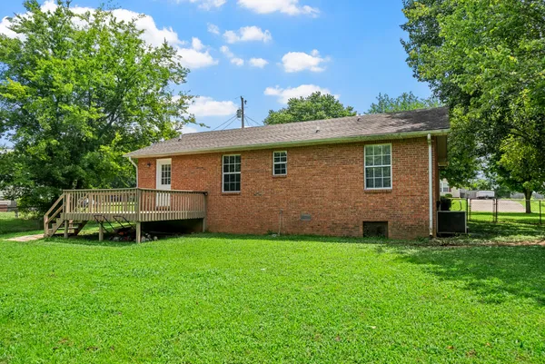 a backyard of a house with potted plants and large tree