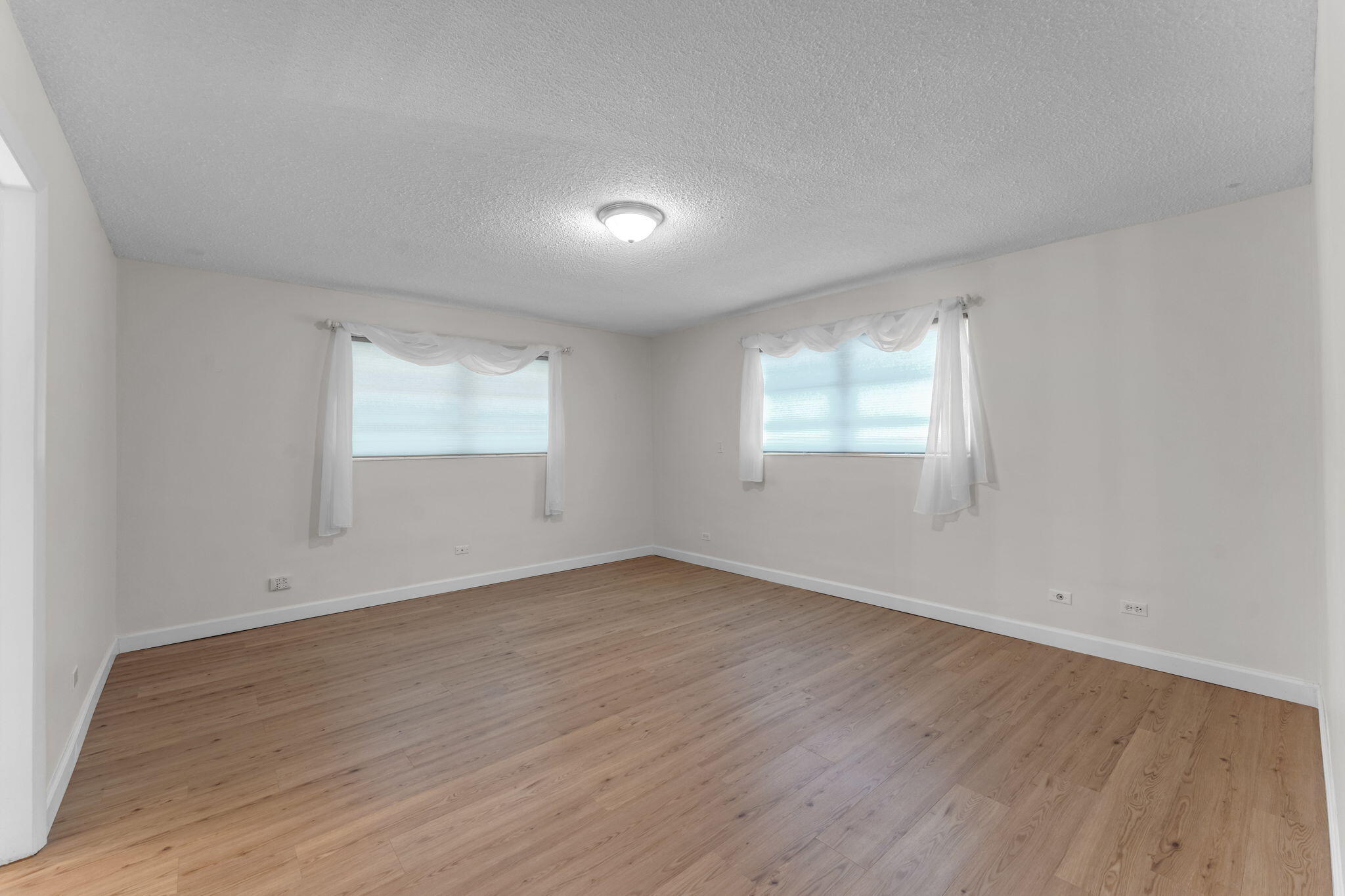 920 La Paloma Road Key Largo, FL 33037 - Photo 21 of 44 an empty room with wooden floor and windows