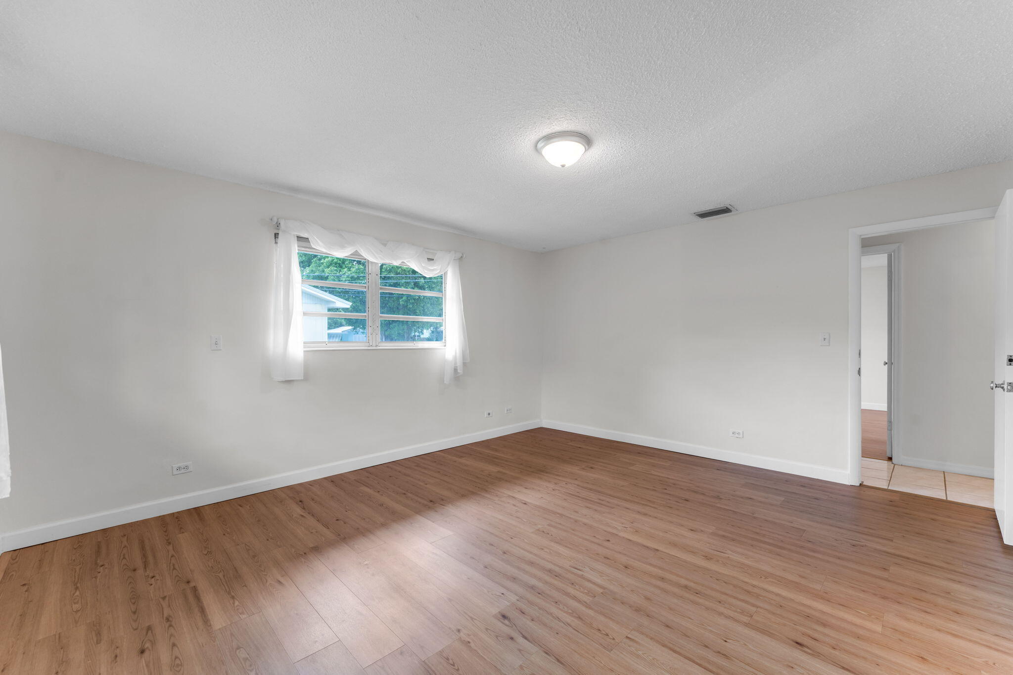 920 La Paloma Road Key Largo, FL 33037 - Photo 23 of 44 an empty room with wooden floor and windows