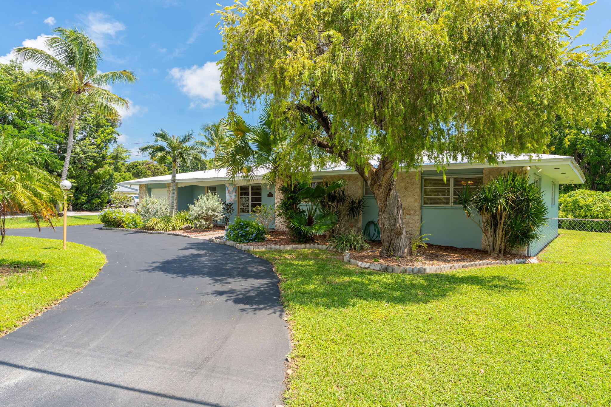 920 La Paloma Road Key Largo, FL 33037 - Photo 5 of 44 a view of a yard with plants and large trees