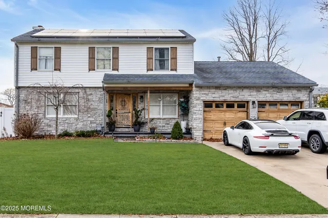 a front view of a house with a garden and trees
