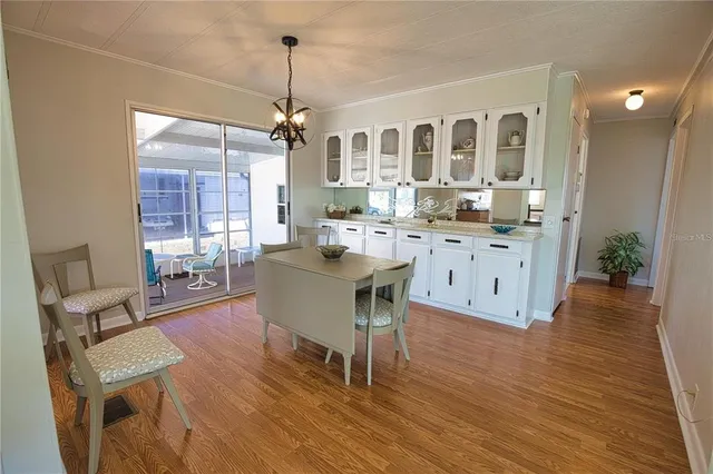 a view of a dining room and livingroom with furniture wooden floor a chandelier
