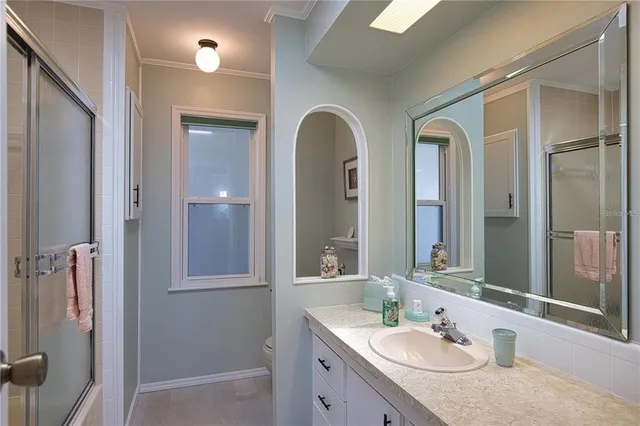 a bathroom with a granite countertop sink a mirror and shower