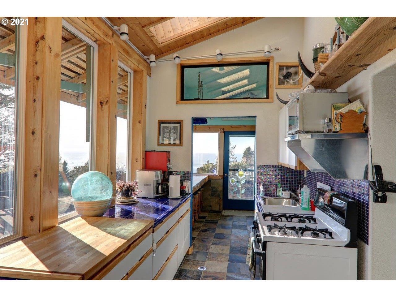 32307 Ruby Lane Cannon Beach, OR 97110 - Photo 18 of 27 a living room with furniture a flat screen tv and floor to ceiling windows