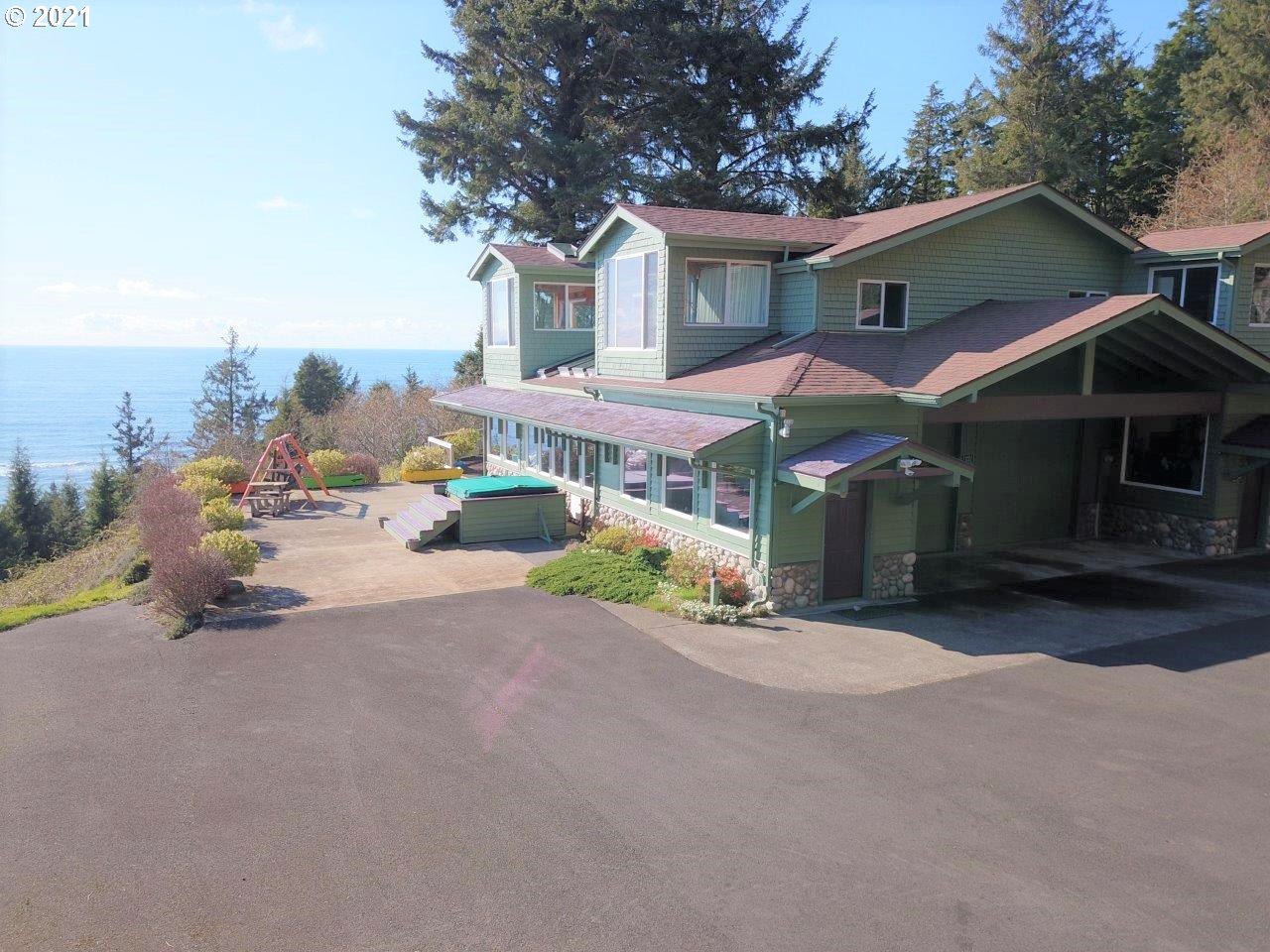 32307 Ruby Lane Cannon Beach, OR 97110 - Photo 2 of 27 a front view of a house with a yard and garage
