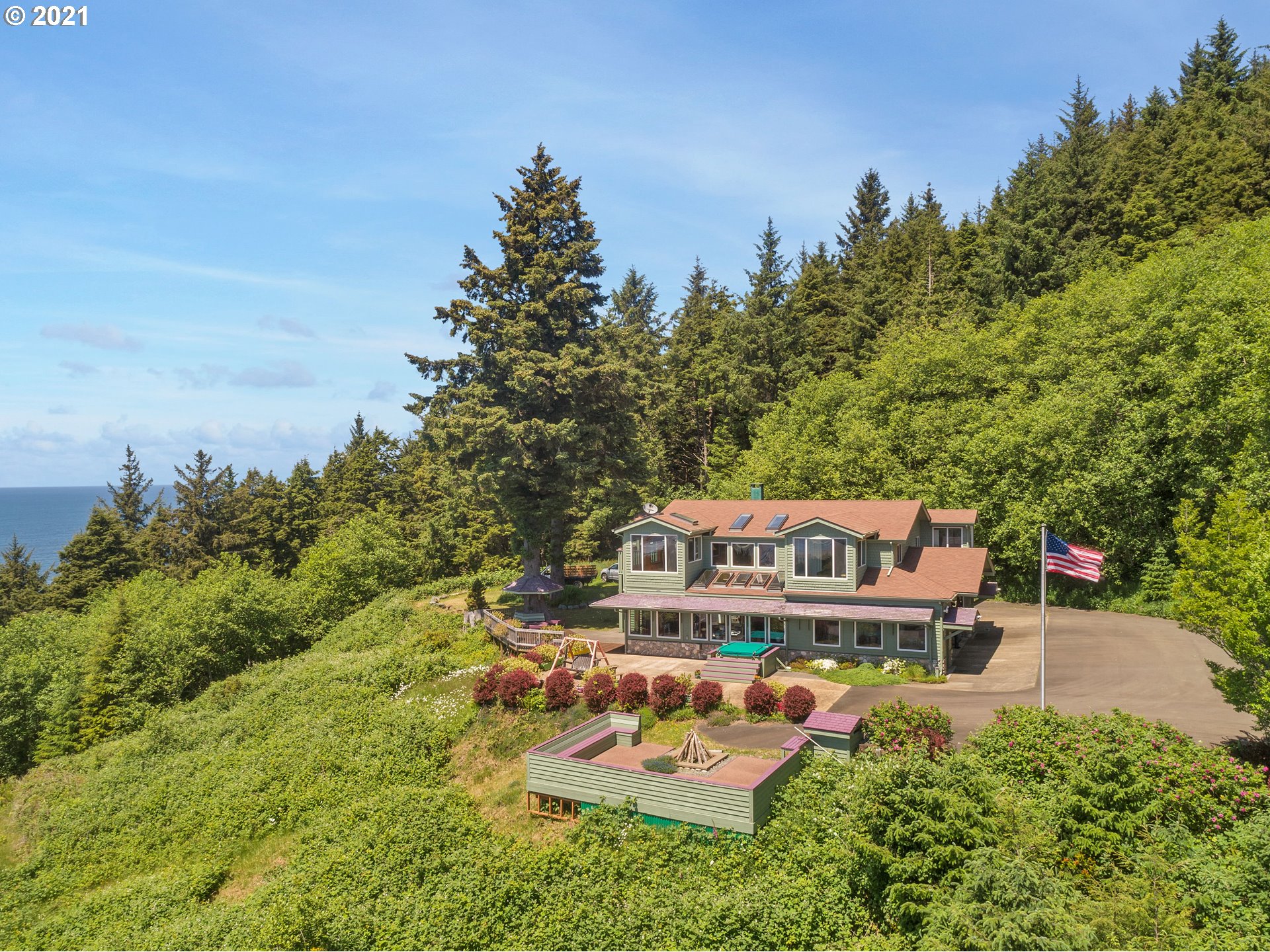 32307 Ruby Lane Cannon Beach, OR 97110 - Photo 3 of 27 an aerial view of a house with swimming pool garden and trees in the background