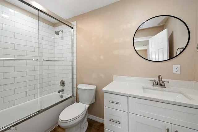 a bathroom with a granite countertop toilet sink and mirror