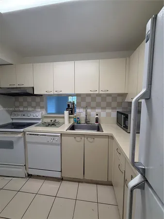 a kitchen with cabinets appliances a sink and a stove