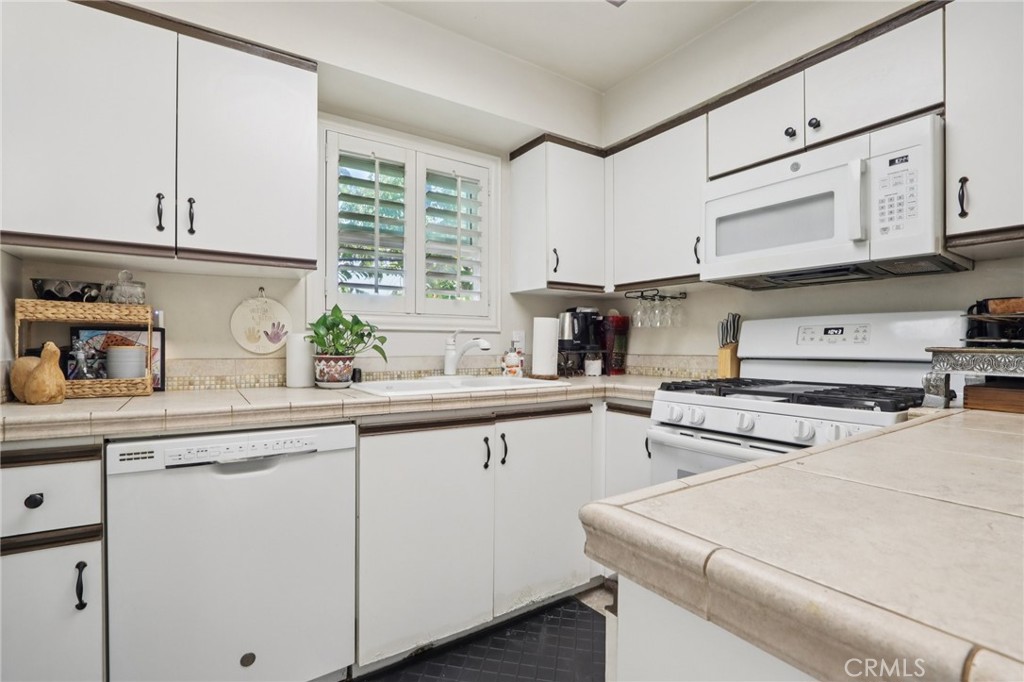 360 South Los Robles Avenue, Unit 11 Pasadena, CA 91101 - Photo 8 of 12 a kitchen with stainless steel appliances white cabinets and a sink
