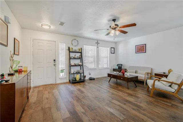 a living room with furniture and wooden floor