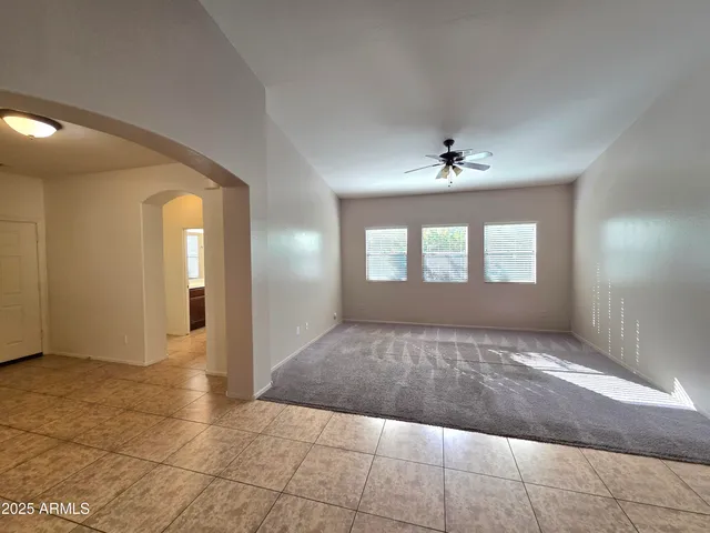 an empty room with windows and chandelier