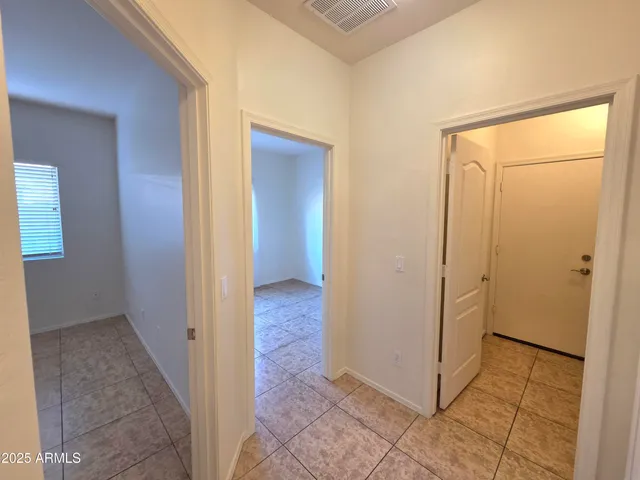 a view of a hallway with wooden floor and a bathroom