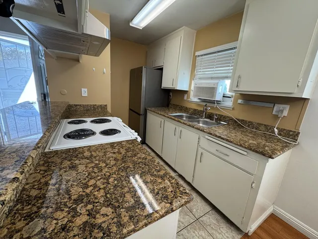 a kitchen with stainless steel appliances granite countertop a stove a sink and a refrigerator