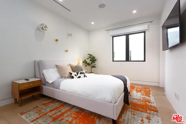 a white bed sitting in a bedroom next to a window