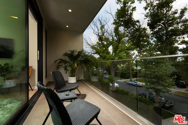 a bedroom with a bed tv and wooden floor