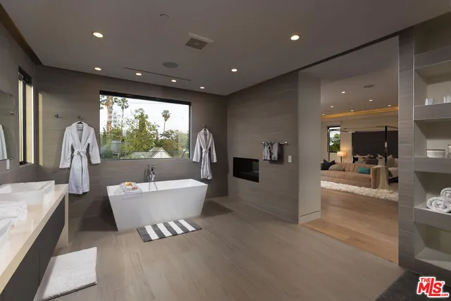 a bathroom with a large tub sink and glass door