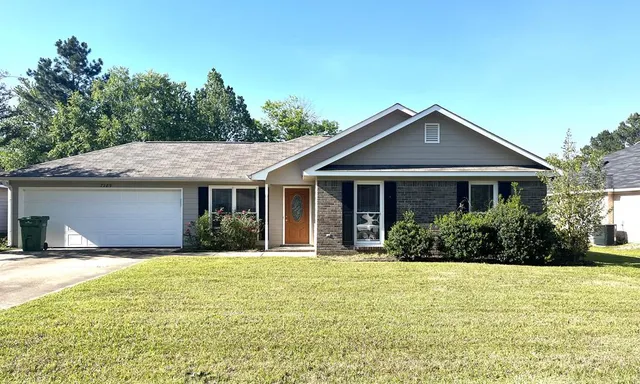 a front view of a house with yard and green space