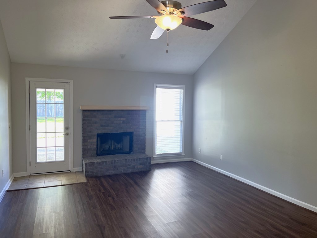 7289 Midland Chase Loop Columbus, GA 31909 - Photo 7 of 19 an empty room with wooden floor fireplace and windows
