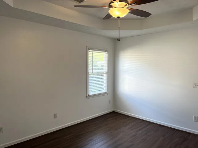 an empty room with a window and a fan