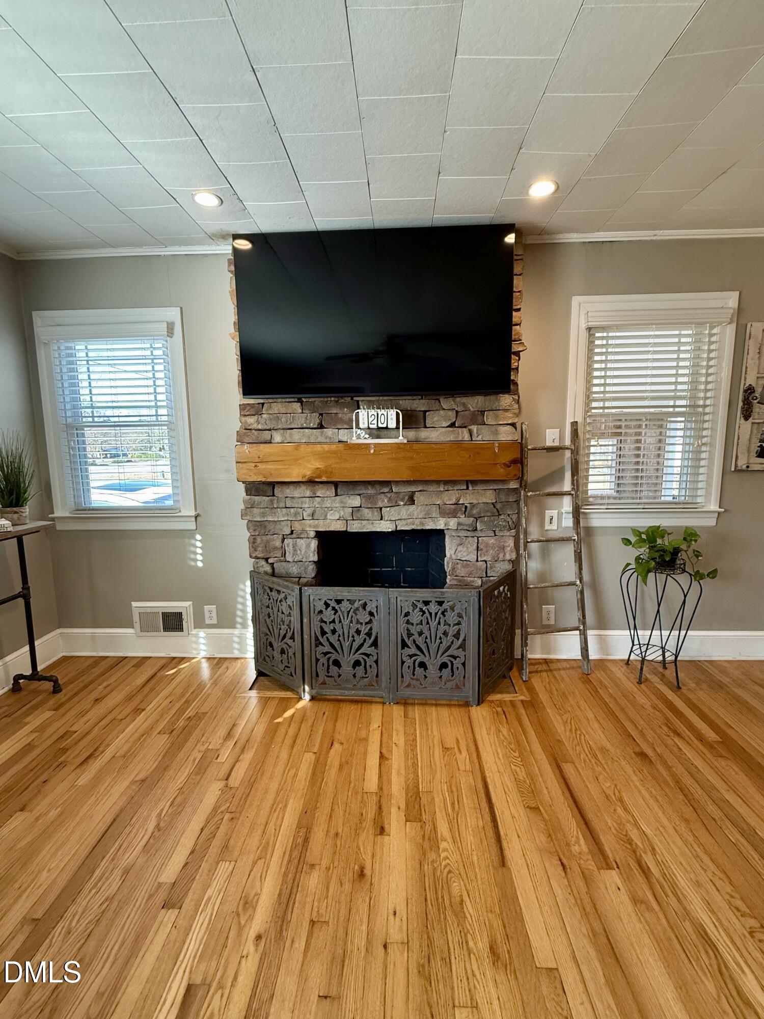 1689 Amelia Church Road Clayton, NC 27520 - Photo 6 of 23 a living room with furniture a flat screen tv and a fireplace