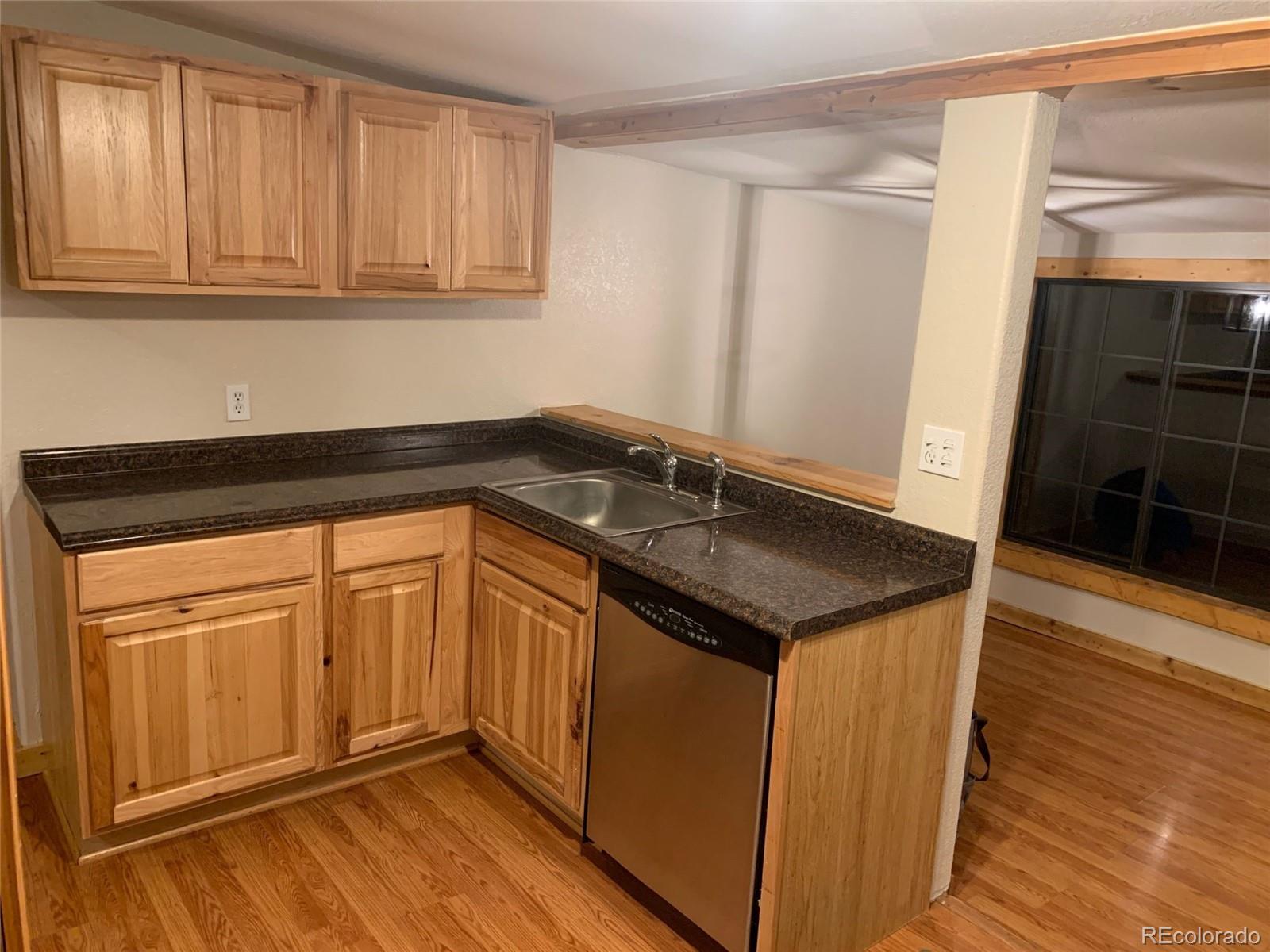 12 Fitzsimmons Road Bailey, CO 80421 - Photo 8 of 26 a kitchen with granite countertop a sink and a wooden floor